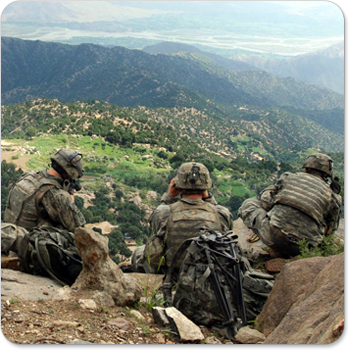 A group of US scout soldiers watch a village in Afganistan