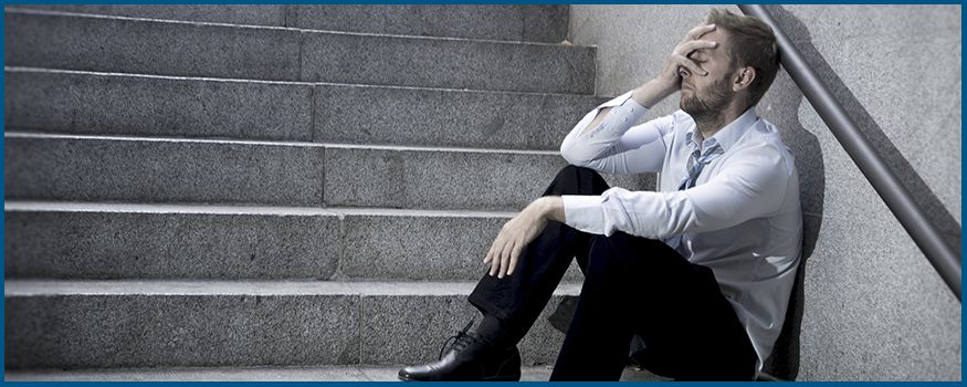Man sitting on steps with his hand on his face