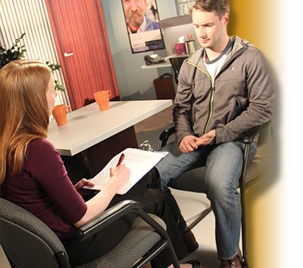 female mental health professional with a male client, writing